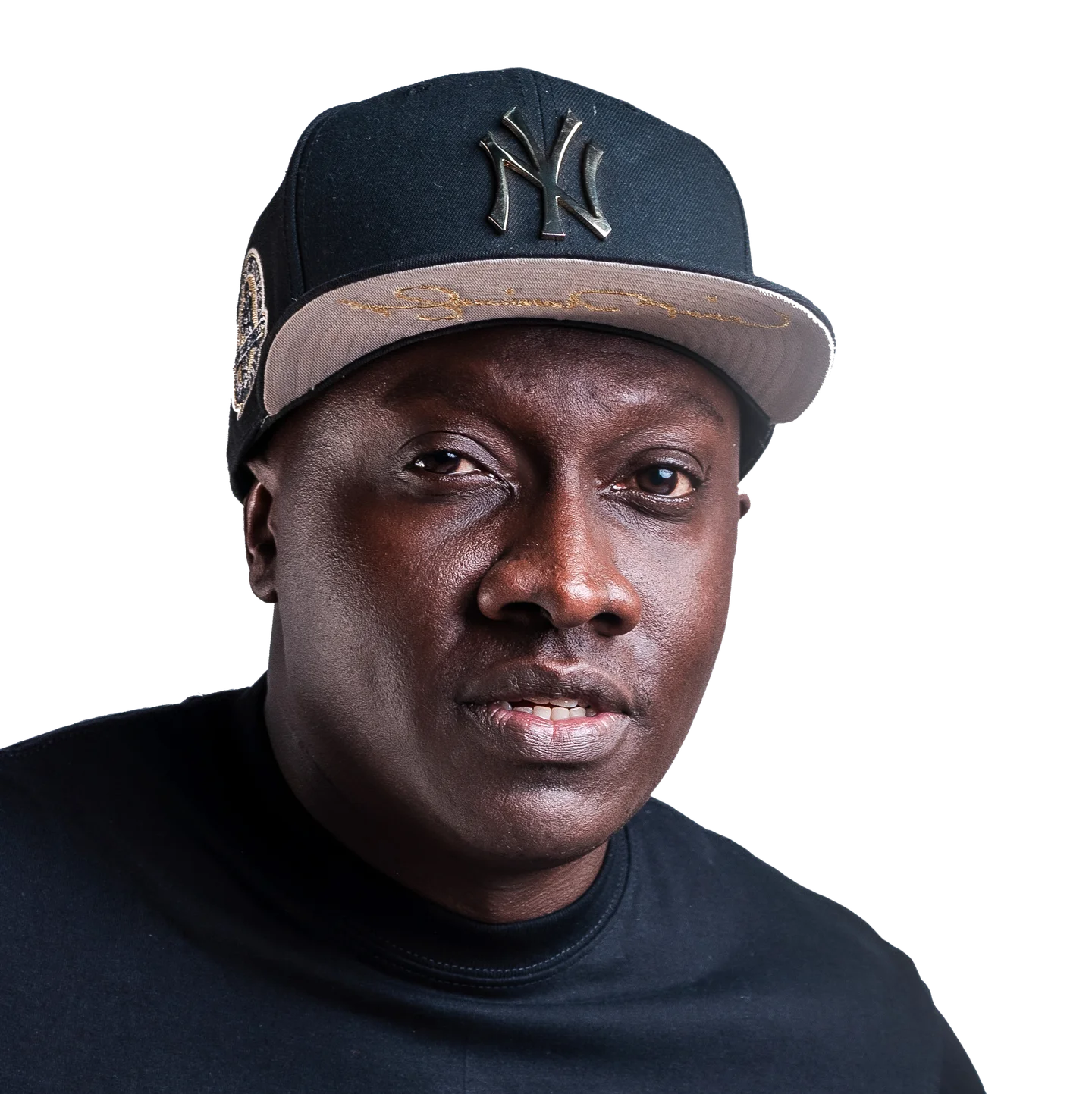 Close portrait of Muzikal Sheriff in a dark cap and black shirt.